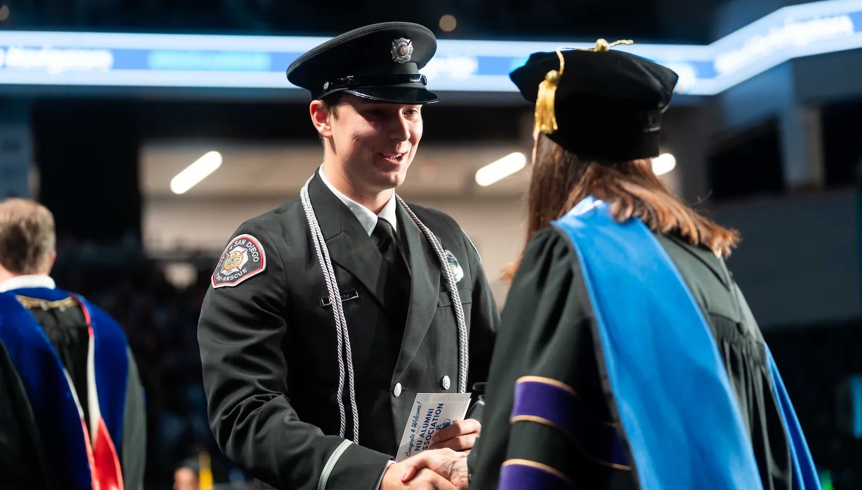 Public service member shaking hand on stage at commencement