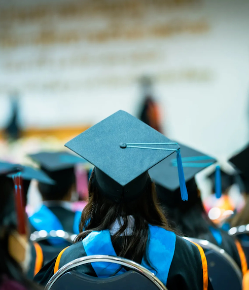 students sitting viewing their caps from behind