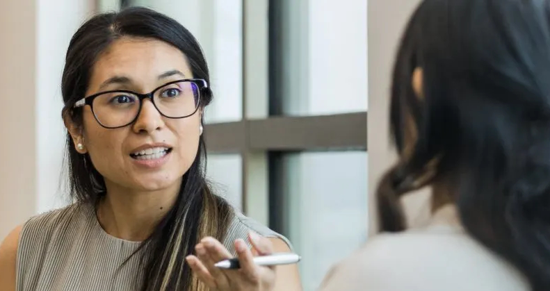 two women having a conversation in an office