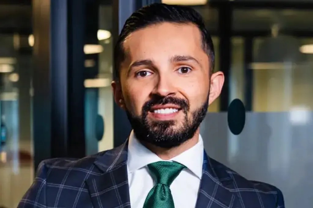 man in checkered blazer and green tie in office