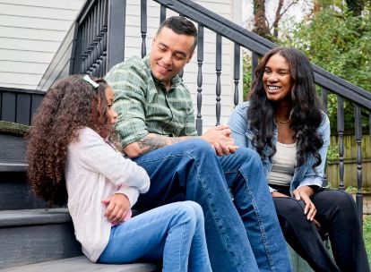 family of 3 sitting on front porch steps