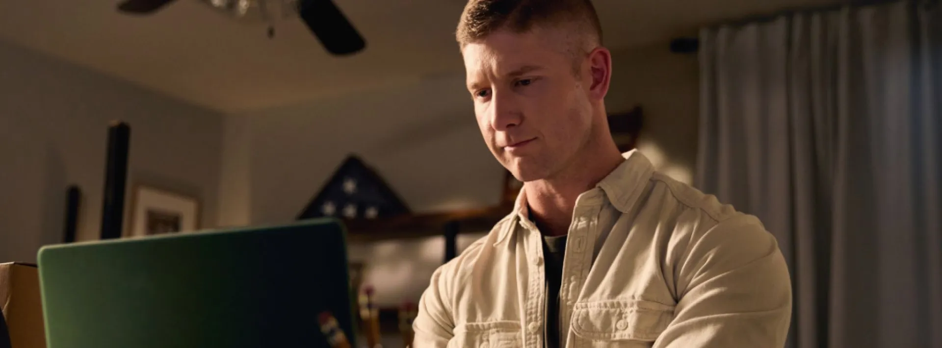 military-veteran-person in tan jean jacket working on laptop