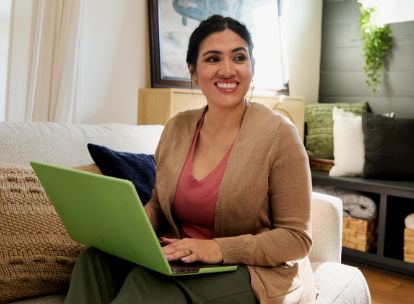person sitting in living room working on green laptop