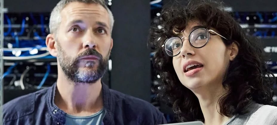 man and woman in server room looking up
