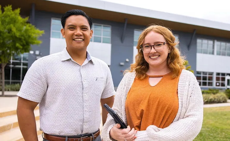 two people outside school holding tablets