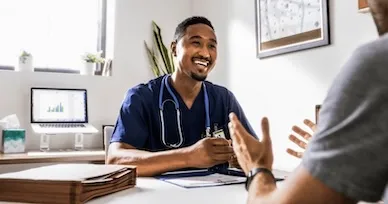 nurse sitting at desk talking to patient