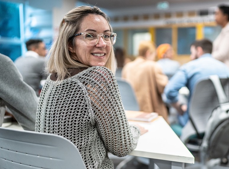 person sitting at desk in classroom looking over shoulder
