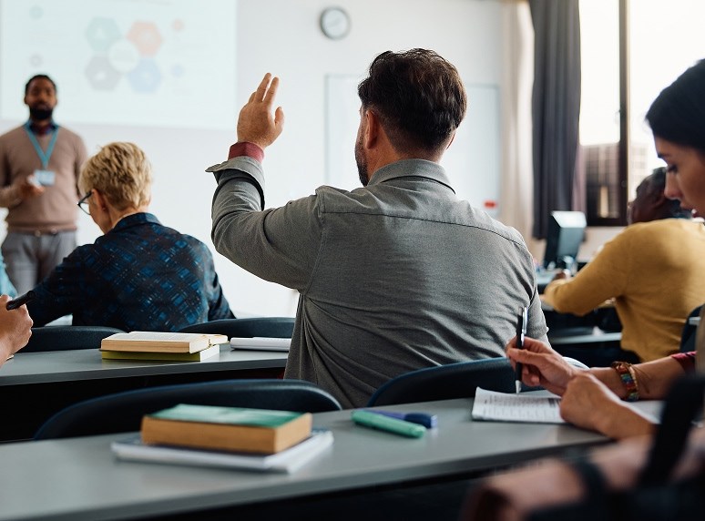 college student in class raising hand