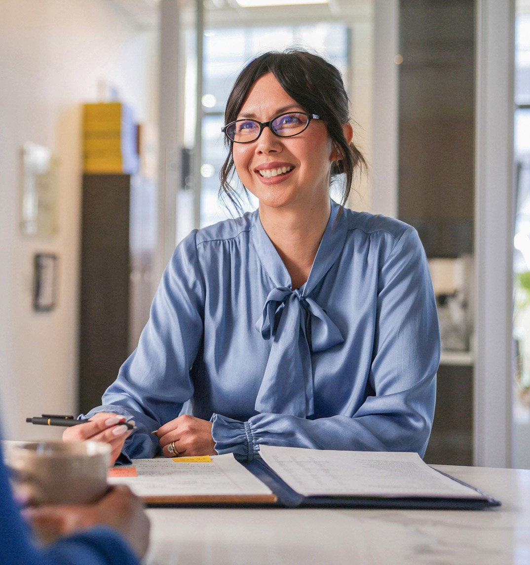 Women in blue shirt with open notebook on table