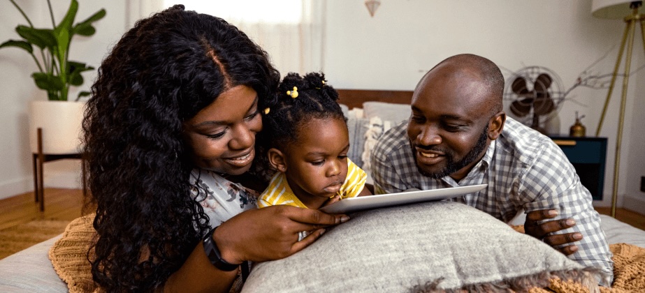 family of 3 reading together in living room