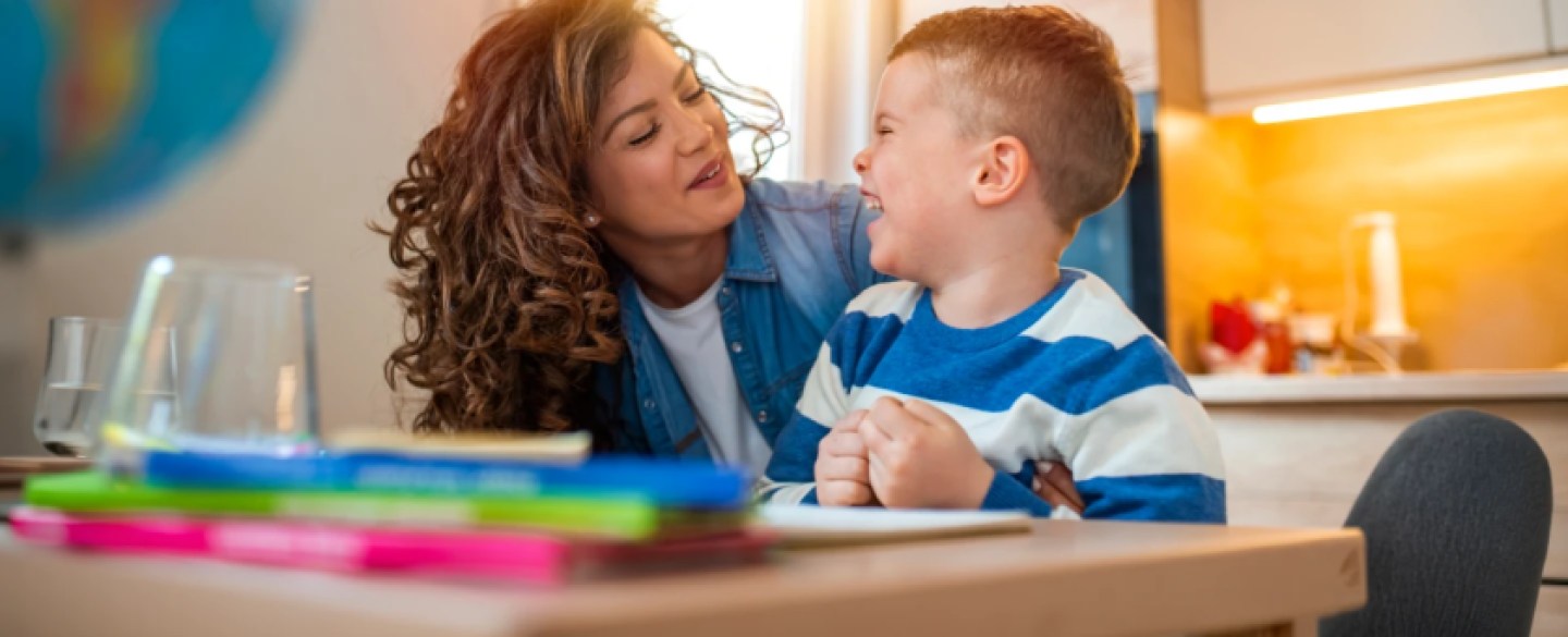 child and mother sitting at kitchen table